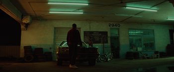 Movie still from “Queen & Slim” (2019), directed by Melina Matsoukas – A man standing next to a car in a garage; Wide shot, Low angle