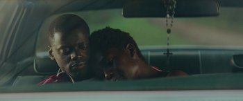 Movie still from “Queen & Slim” (2019), directed by Melina Matsoukas – Two men in the back seat of a car; Close Up shot, High angle