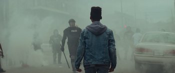 Movie still from “Queen & Slim” (2019), directed by Melina Matsoukas – A group of men walking through a fog covered street; Medium shot, Low angle