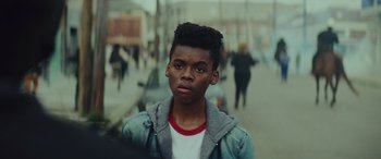 Movie still from “Queen & Slim” (2019), directed by Melina Matsoukas – A young black man with a beard and a jacket on; Close Up shot, Over the shoulder angle