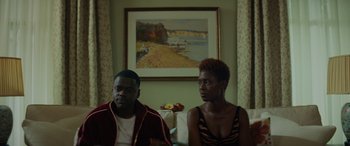 Movie still from “Queen & Slim” (2019), directed by Melina Matsoukas – A man and a woman sitting on a couch in a living room; Medium shot, Over the shoulder angle