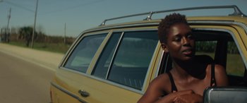 Movie still from “Queen & Slim” (2019), directed by Melina Matsoukas – A woman standing next to a yellow car; Close Up shot, Over the shoulder angle