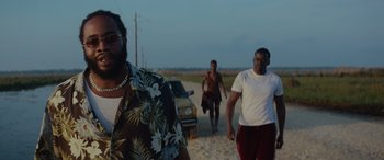 Movie still from “Queen & Slim” (2019), directed by Melina Matsoukas – A group of people walking down a dirt road; Medium shot, Over the shoulder angle