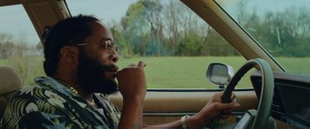 Movie still from “Queen & Slim” (2019), directed by Melina Matsoukas – A man sitting in the driver's seat of a car; Close Up shot, Low angle