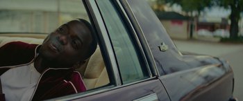 Movie still from “Queen & Slim” (2019), directed by Melina Matsoukas – A man sitting in the driver's seat of a car looking out of the window; Close Up shot, Over the shoulder angle
