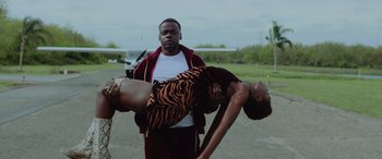 Movie still from “Queen & Slim” (2019), directed by Melina Matsoukas – A man and a woman are standing in front of an airplane; Medium shot, Low angle