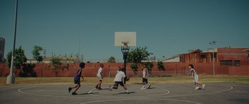 Movie still from “Queen & Slim” (2019), directed by Melina Matsoukas – A group of young men playing a game of basketball; Extreme Wide shot, High angle