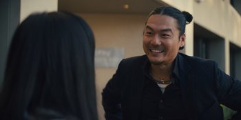 Movie still from “Quiz Lady” (2023), directed by Jessica Yu – A man in a black jacket is talking to a woman; Close Up shot, Over the shoulder angle
