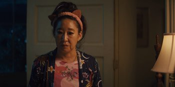 Movie still from “Quiz Lady” (2023), directed by Jessica Yu – A woman wearing a cat ear headband in front of a door; Close Up shot, Over the shoulder angle