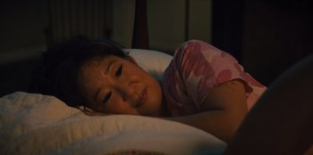 Movie still from “Quiz Lady” (2023), directed by Jessica Yu – A woman is sleeping in her bed with her eyes closed; Close Up shot, High angle