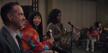 Movie still from “Quiz Lady” (2023), directed by Jessica Yu – Two women holding wii remotes in front of microphones; Medium shot, Over the shoulder angle