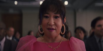 Movie still from “Quiz Lady” (2023), directed by Jessica Yu – A person wearing a pink dress; Close Up shot, Over the shoulder angle