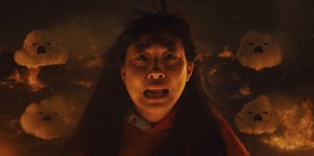 Movie still from “Quiz Lady” (2023), directed by Jessica Yu – A woman with long black hair is looking at the camera; Close Up shot, Low angle