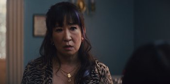 Movie still from “Quiz Lady” (2023), directed by Jessica Yu – A person wearing a leopard print jacket; Close Up shot, Over the shoulder angle