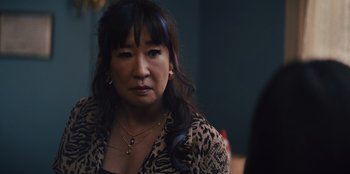 Movie still from “Quiz Lady” (2023), directed by Jessica Yu – A person with long hair; Close Up shot, Over the shoulder angle