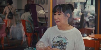Movie still from “Quiz Lady” (2023), directed by Jessica Yu – An older woman sitting at a table in a restaurant; Close Up shot, Over the shoulder angle