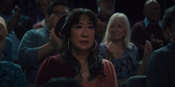 Movie still from “Quiz Lady” (2023), directed by Jessica Yu – An asian woman is standing in front of an audience; Close Up shot, Over the shoulder angle