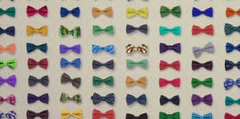 Movie still from “Quiz Lady” (2023), directed by Jessica Yu – A wall of different colored bow ties on a wall; Extreme Close Up shot, Overhead angle