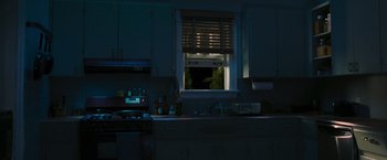 Movie still from “RED” (2010), directed by Robert Schwentke – A kitchen with a sink , stove , microwave and a window; Extreme Wide shot, High angle