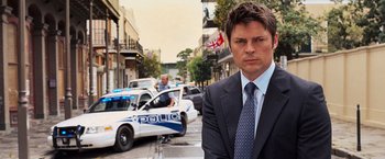 Movie still from “RED” (2010), directed by Robert Schwentke – A man standing in front of a police car; Close Up shot, Low angle