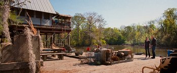 Movie still from “RED” (2010), directed by Robert Schwentke – A dock with several items on it near the water; Extreme Wide shot, High angle