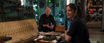 Movie still from “RED” (2010), directed by Robert Schwentke – A man and a woman sitting in a living room; Medium shot, Over the shoulder angle