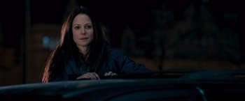 Movie still from “RED” (2010), directed by Robert Schwentke – A woman sitting in the driver's seat of a car at night; Close Up shot, Over the shoulder angle