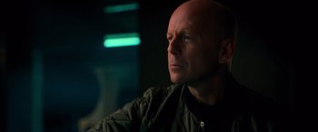 Movie still from “RED” (2010), directed by Robert Schwentke – A man with a bald head looking into the distance; Close Up shot, Low angle