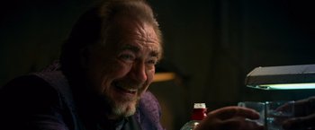 Movie still from “RED” (2010), directed by Robert Schwentke – An older man sitting in front of a bottle of soda; Close Up shot, Over the shoulder angle