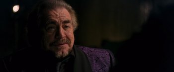 Movie still from “RED” (2010), directed by Robert Schwentke – An older man wearing a suit and a purple jacket; Close Up shot, Over the shoulder angle