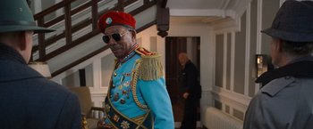 Movie still from “RED” (2010), directed by Robert Schwentke – An older man wearing a red hat and a blue uniform; Medium shot, Low angle