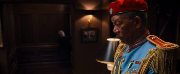 Movie still from “RED” (2010), directed by Robert Schwentke – An older man wearing a red hat and a blue jacket; Medium shot, Over the shoulder angle