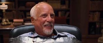 Movie still from “RED” (2010), directed by Robert Schwentke – An older man sitting in an office chair; Close Up shot, Low angle