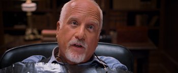 Movie still from “RED” (2010), directed by Robert Schwentke – An older man sitting in an office chair; Close Up shot, Over the shoulder angle