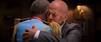 Movie still from “RED” (2010), directed by Robert Schwentke – A man hugging another man in a suit and tie; Close Up shot, Over the shoulder angle