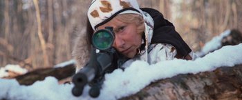 Movie still from “RED” (2010), directed by Robert Schwentke – A woman in a camouflage jacket is aiming a rifle; Close Up shot, Over the shoulder angle
