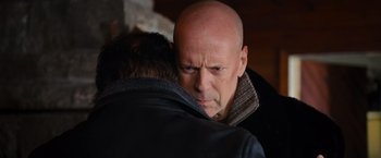 Movie still from “RED” (2010), directed by Robert Schwentke – A man with a bald head hugging another man; Close Up shot, Over the shoulder angle