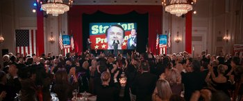 Movie still from “RED” (2010), directed by Robert Schwentke – A crowd of people in front of a large screen; Wide shot, Low angle