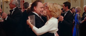 Movie still from “RED” (2010), directed by Robert Schwentke – A man and a woman embracing each other in front of a crowd of onlookers; Medium shot, Low angle