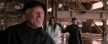 Movie still from “RED” (2010), directed by Robert Schwentke – A man and two women are standing in a building; Close Up shot, Over the shoulder angle