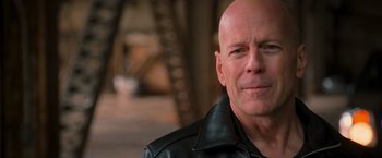 Movie still from “RED” (2010), directed by Robert Schwentke – A bald man in a leather jacket looks at the camera; Close Up shot, Over the shoulder angle