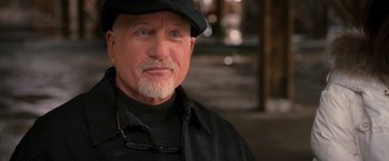 Movie still from “RED” (2010), directed by Robert Schwentke – An older man wearing a black hat and a black jacket; Close Up shot, Over the shoulder angle