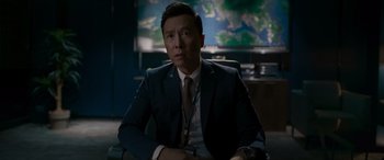 Movie still from “Raging Fire” (2021), directed by Benny Chan – A man sitting in a chair in front of a map; Medium shot, Over the shoulder angle
