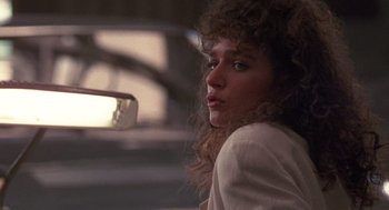 Movie still from “Rain Man” (1988), directed by Barry Levinson – A young woman with long curly brown hair and blue eyes; Close Up shot, Low angle