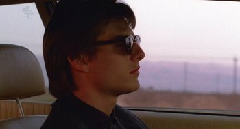 Movie still from “Rain Man” (1988), directed by Barry Levinson – A young man wearing sunglasses sitting in a car; Close Up shot, Low angle
