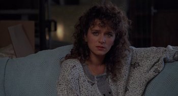 Movie still from “Rain Man” (1988), directed by Barry Levinson – A woman sitting in a chair looking at the camera; Close Up shot, Over the shoulder angle