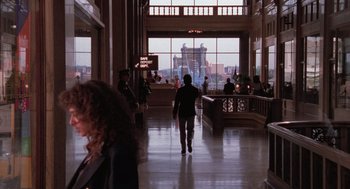 Movie still from “Rain Man” (1988), directed by Barry Levinson – A person walking in a large room with a view of a city; Wide shot, Over the shoulder angle