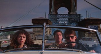 Movie still from “Rain Man” (1988), directed by Barry Levinson – A group of people riding in a car on a road; Medium shot, Low angle