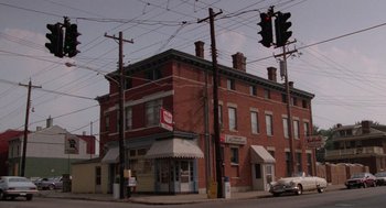 Movie still from “Rain Man” (1988), directed by Barry Levinson – An old brick building on a street corner with a traffic light; Extreme Wide shot, High angle