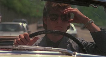Movie still from “Rain Man” (1988), directed by Barry Levinson – A young man driving a car in the street; Close Up shot, Low angle